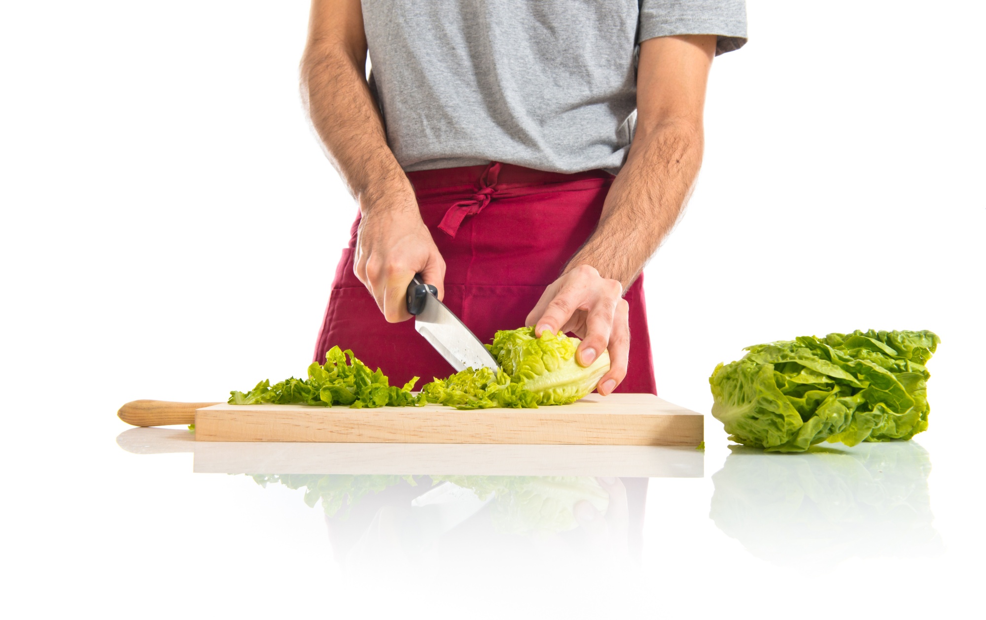Chef che affetta ingredienti su tagliere in cucina artigianale